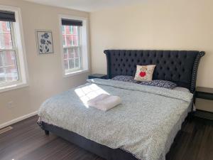 巴尔的摩Sweet bedroom located central of downtown的一间卧室配有一张带黑色床头板和窗户的床。