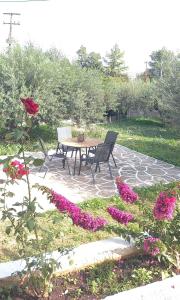 伊斯米亚The Byzantine Wall House的庭院配有桌椅和鲜花