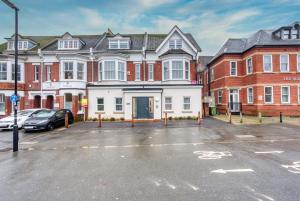 南安普敦1 BR, central Southampton, Stunning Apt by Blue Puffin Stays的大楼前的一个空停车位