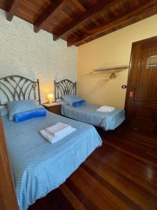 圣地亚哥－德孔波斯特拉Casa de Costoia的一间卧室设有两张床和一扇门