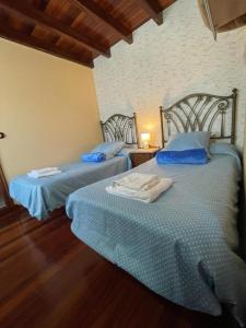 圣地亚哥－德孔波斯特拉Casa de Costoia的两张睡床彼此相邻,位于一个房间里