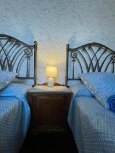 圣地亚哥－德孔波斯特拉Casa de Costoia的木床头柜上的两张带灯的床