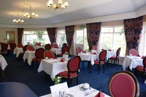 Saint Peter Port农庄酒店的用餐室设有桌椅和窗户。