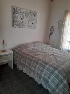 圣卡洛斯-德巴里洛切CASITA DE LAS CHACRAS SOBRE EL LAGO的一间卧室配有一张床、一张桌子和一个窗户。