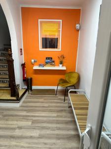 普奇塞达Hostal ARS的走廊上设有橙色墙壁和黄色椅子