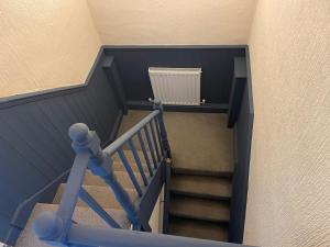 格兰瑟姆Contractor & Family House - Central Grantham的带有蓝色栏杆和散热器的楼梯