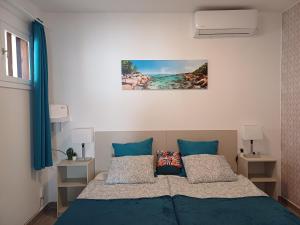 科斯塔特吉塞Happy Heart Los Molinos的一间卧室配有一张带蓝色床单和枕头的床。