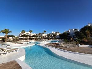 科斯塔特吉塞Happy Heart Los Molinos的度假村内的一个蓝色海水游泳池
