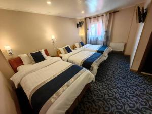 蒙特港Hotel Vista Mar的酒店客房设有三张床和窗户。