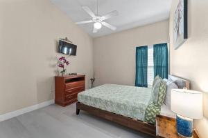 奥兰多Poolside Orlando Oasis的一间卧室配有一张床和吊扇