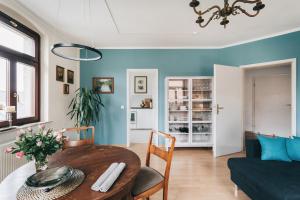 德累斯顿Apartment Maria Luisa的客厅设有木桌和蓝色的墙壁。