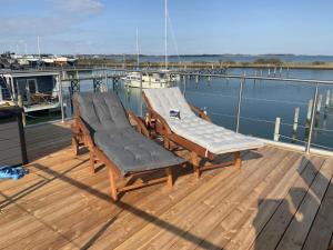 TorrigHausboot Moby Chic mit Dachterrasse in Kragenæs auf Lolland/DK的船上甲板上的两把椅子和一张桌子