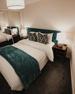 格拉斯哥Royal Chambers Serviced Apartments的一间卧室配有一张大床和两盏灯。