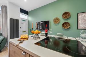 朴次茅斯3 Bed Spacious Stylish House, Central Portsmouth Sleeps 6, Parking - By Blue Puffin Stays的厨房配有带1瓶葡萄酒的台面