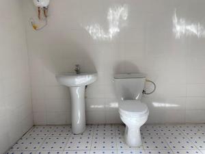 BrikamaIzzy Guest House的白色的浴室设有卫生间和水槽。