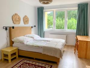 齐斯纳Między górami. Apartament w Cisnej的一间卧室配有一张带绿色窗帘的床和窗户。