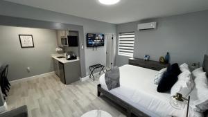 代托纳海滩Oceano Suites Daytona Beach的一间带白色床的卧室和一间厨房