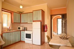 劳德哈塔liocharis villas的厨房配有白色冰箱和桌子