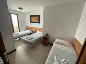 萨拉戈萨Pensión Fortea的小房间设有两张床和一张桌子