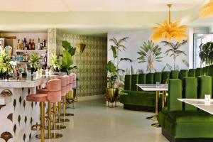 洛杉矶Sonder The Beacon的餐厅拥有绿色家具和植物墙壁