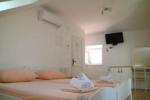 斯潘卡卢卡Studio Apartments & Rooms Lela的白色卧室配有两张带毛巾的床