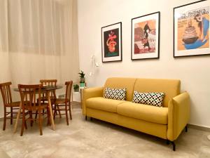 米兰La Cadrega的客厅配有黄色的沙发和桌子