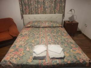 利马索尔艾琳娜斯公寓的一间卧室配有一张床,上面有两条毛巾