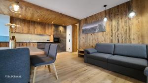 奥蒂塞伊Villa Dolomiti的客厅设有木墙和桌椅