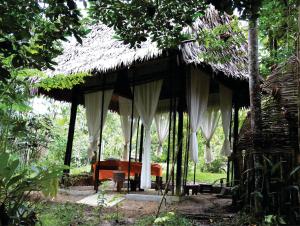莱蒂西亚Amazona Lodge的一个带床和茅草屋顶的度假胜地