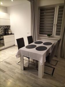 乌斯特龙Apartament Ustroń Jaszowiec的餐桌、椅子和白色桌布