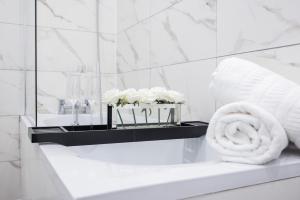 克罗伊登Brand New Modern Block of Apartments By AV Stays Short Lets London的浴室设有水槽、浴缸和毛巾。