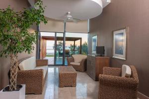 DenizyakaLykia World Links Golf Antalya的客厅配有藤椅和电视