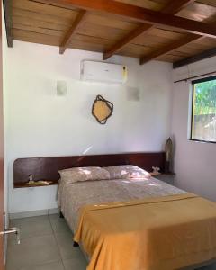 南蒂包Sítio Vila das Flores的卧室配有白色墙壁上的床铺