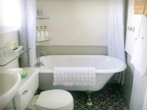 长滩Casita Charm, Cozy Character的带浴缸、卫生间和盥洗盆的浴室