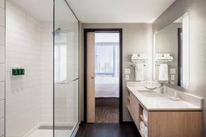 卡尔加里Residence Inn by Marriott Calgary Downtown/Beltline District的带淋浴、盥洗盆和镜子的浴室