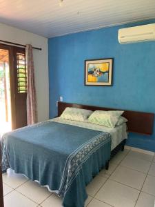 南蒂包Sítio Vila das Flores的一间卧室配有一张蓝色墙壁的床