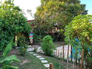 南蒂包Sítio Vila das Flores的花园,花园中设有栅栏,种植了植物和树木