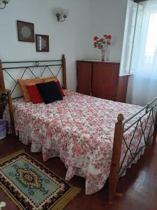英雄港Casa da Atalaia的一间卧室配有一张带红色和白色棉被的床