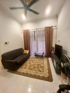 Homestay Seri Aman Pasir Puteh的带沙发和电视的客厅