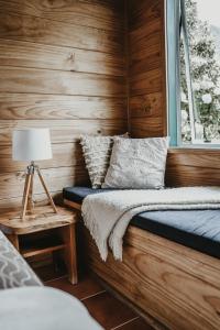 哈海海滩度假村塔塔希小屋酒店的一间卧室设有木墙和一张带窗户的床