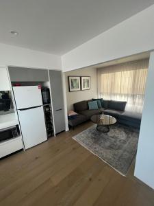 墨尔本Ruckers Hill Northcote Penthouse的带沙发和冰箱的客厅