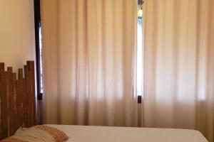 弗雷谢拉斯Flecheiras Eco Residence Un302的一间卧室配有床和带窗帘的窗户