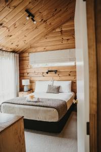 哈海海滩度假村塔塔希小屋酒店的一间卧室设有一张木天花板床。