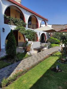 阿雷基帕Casa Baraquel的一座带长凳和草地庭院的建筑
