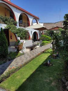 阿雷基帕Casa Baraquel的一座花园,在一座建筑前设有长凳和遮阳伞