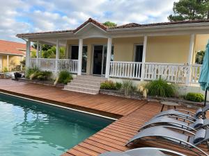 拉卡诺奥肯Villa du Golf Eden Parc的一座带木甲板和游泳池的房子