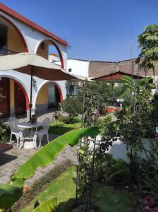 阿雷基帕Casa Baraquel的庭院配有桌椅和遮阳伞。