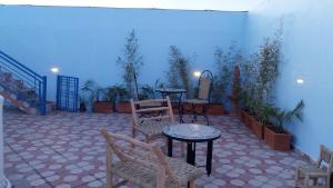 塞拉Dar Ribati的庭院配有两把椅子、一张桌子和一张桌子以及椅子。