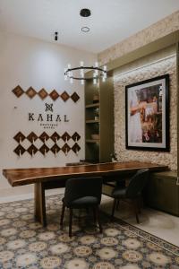 梅里达Kahal Boutique Hotel的一间带木桌和椅子的用餐室