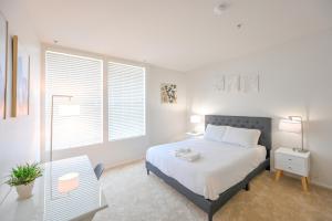 洛杉矶Cozy Home Management in MDR的白色卧室设有床、桌子和窗户